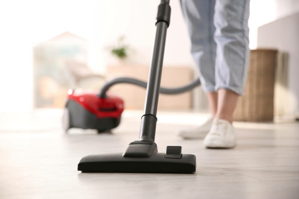 Young Woman Using Vacuum Cleaner